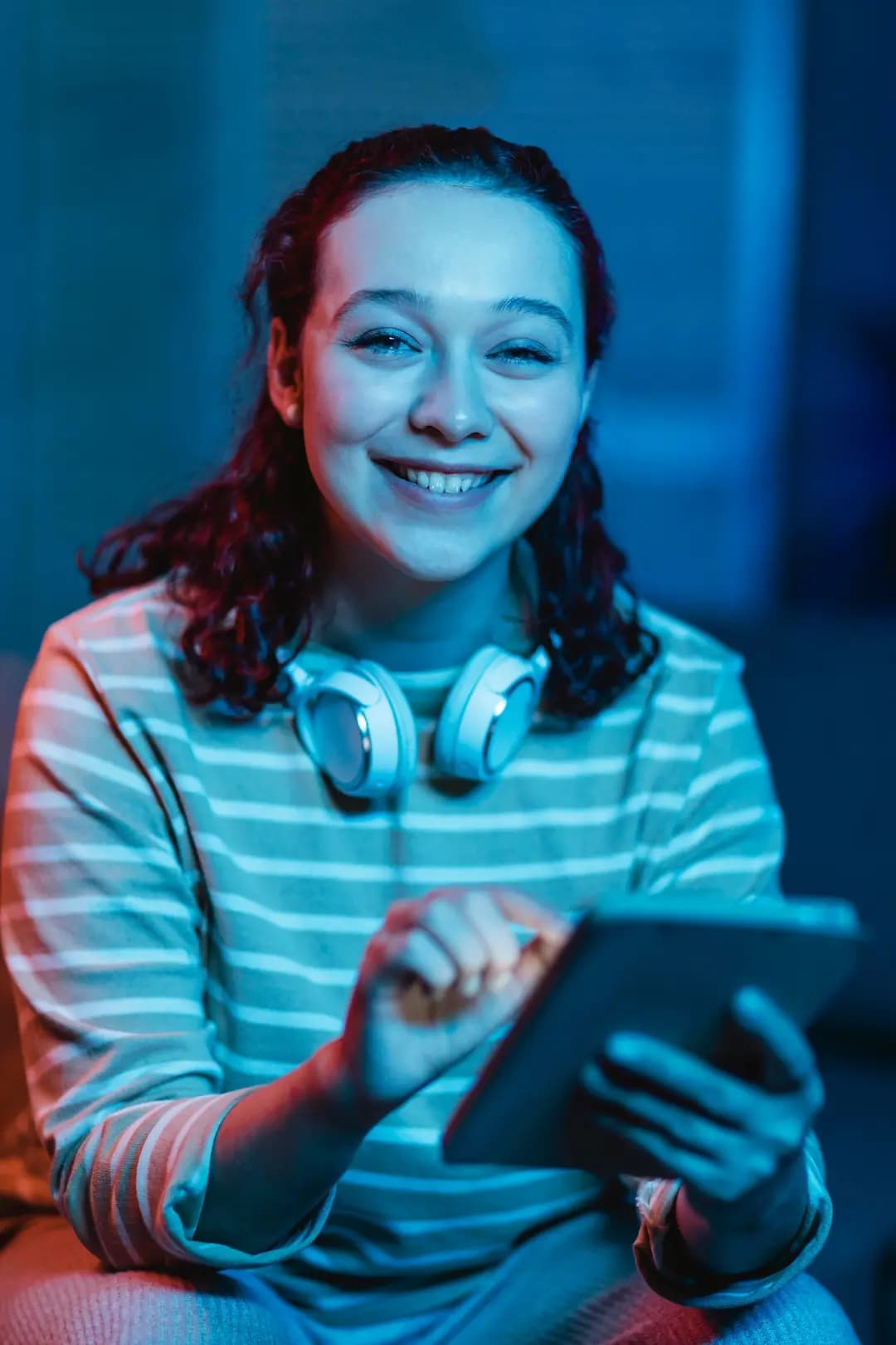 Profesional sonriendo mientras revisa vacantes en su tableta
